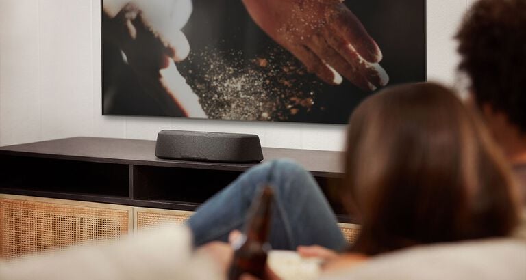 Compact soundbar sitting on a dresser.