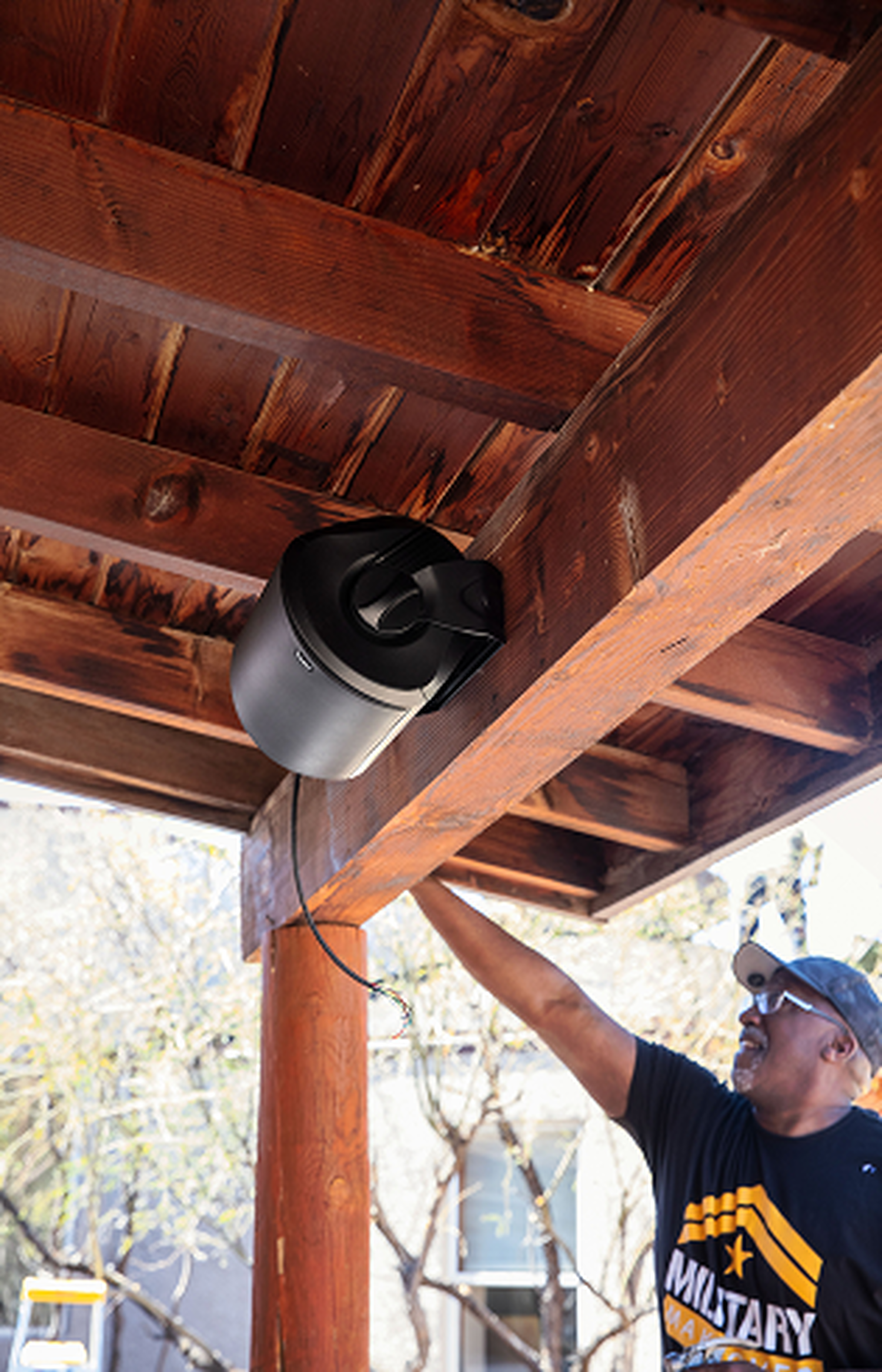 A man mounting an outdoor speaker