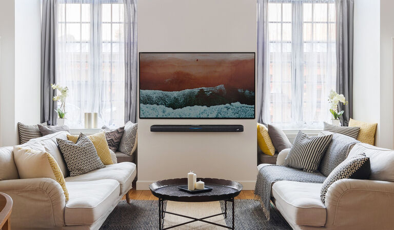 A furnished room with a mounted TV and soundbar.