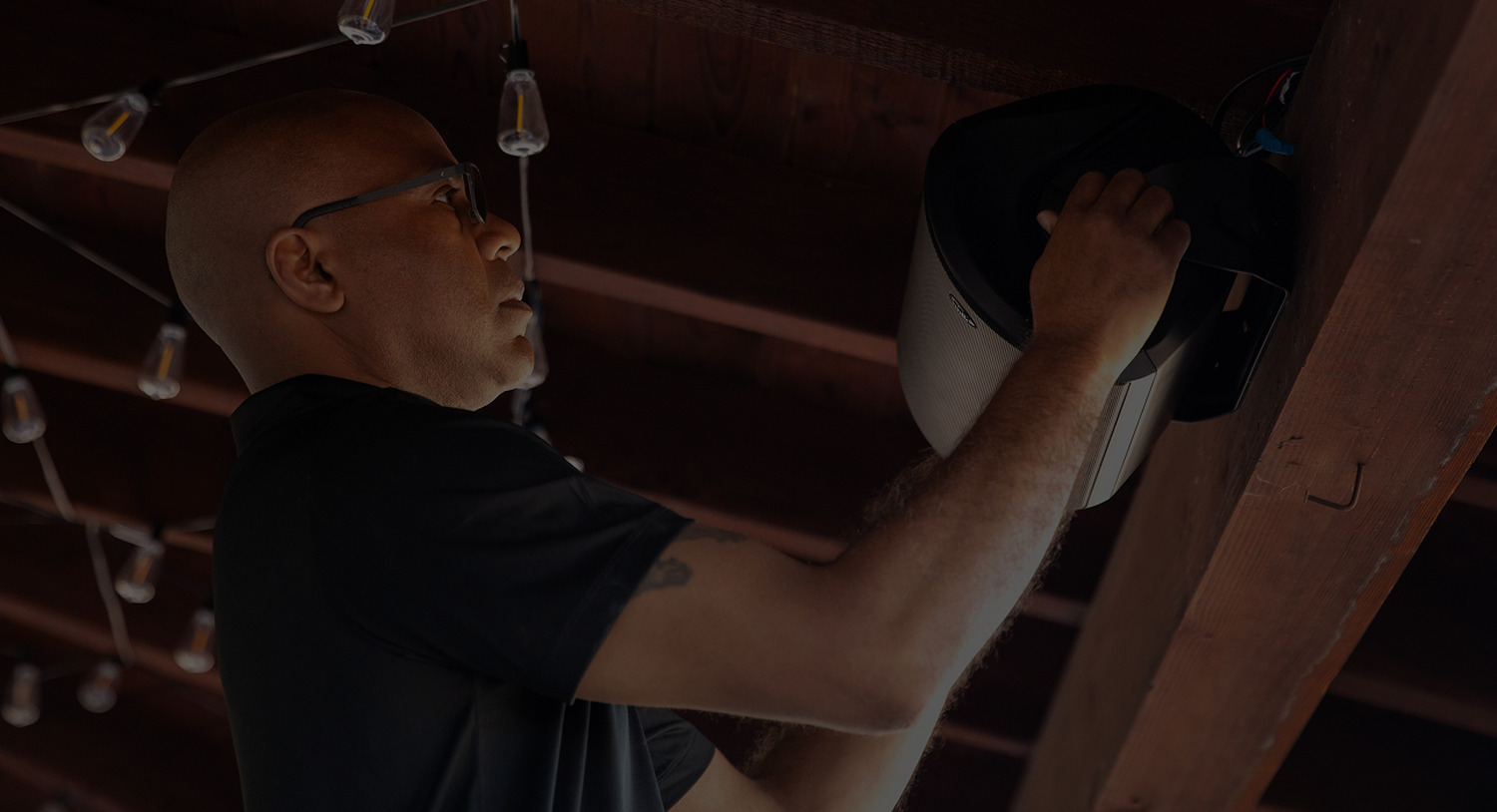 A man mounting  a speaker outdoors
