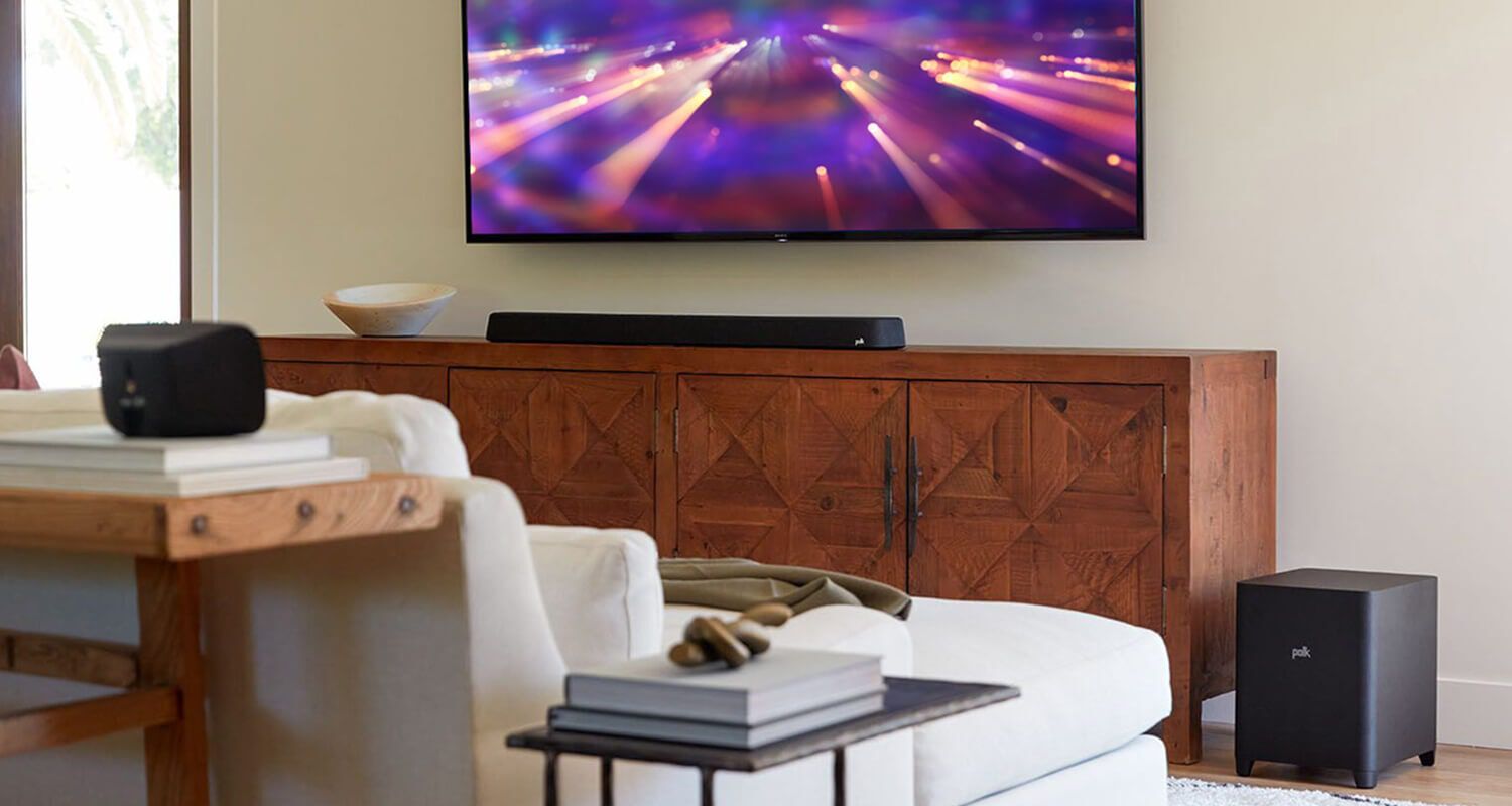 A furnished room with a mounted TV and soundbar.