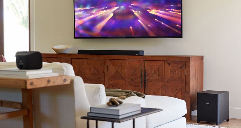 A furnished room with a mounted TV and soundbar.