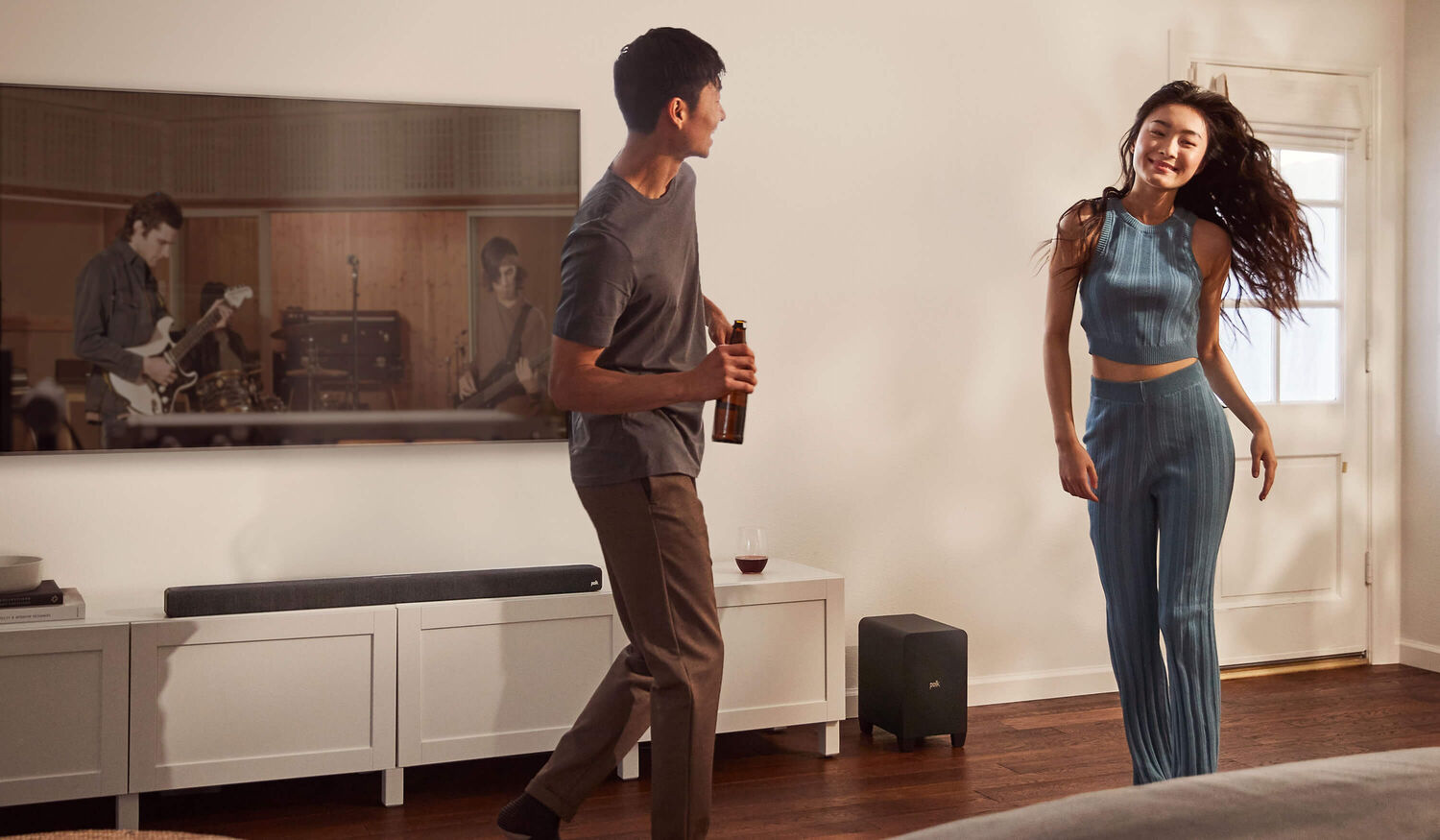 A couple dancing with music from a sound bar.