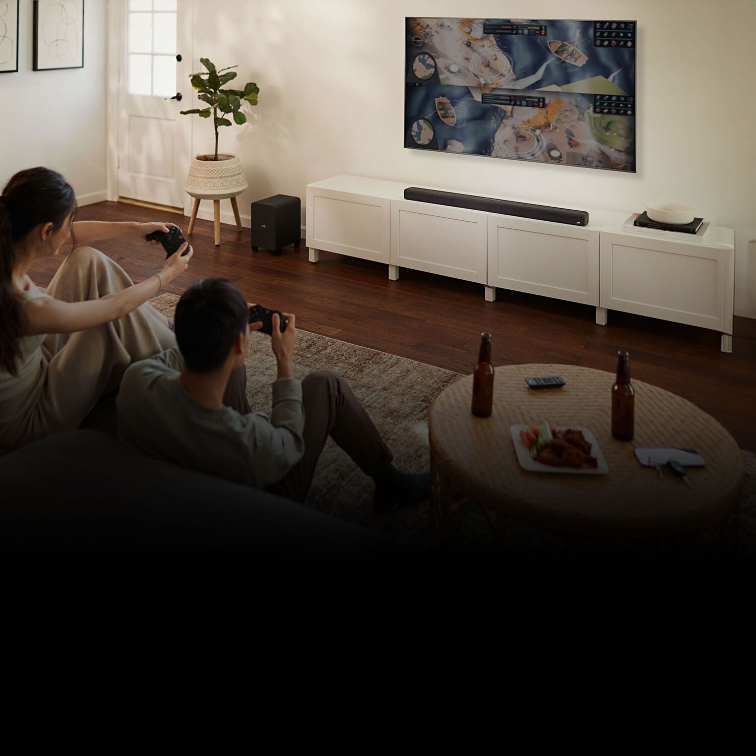 Couple playing games on a tv with Polk sound bar