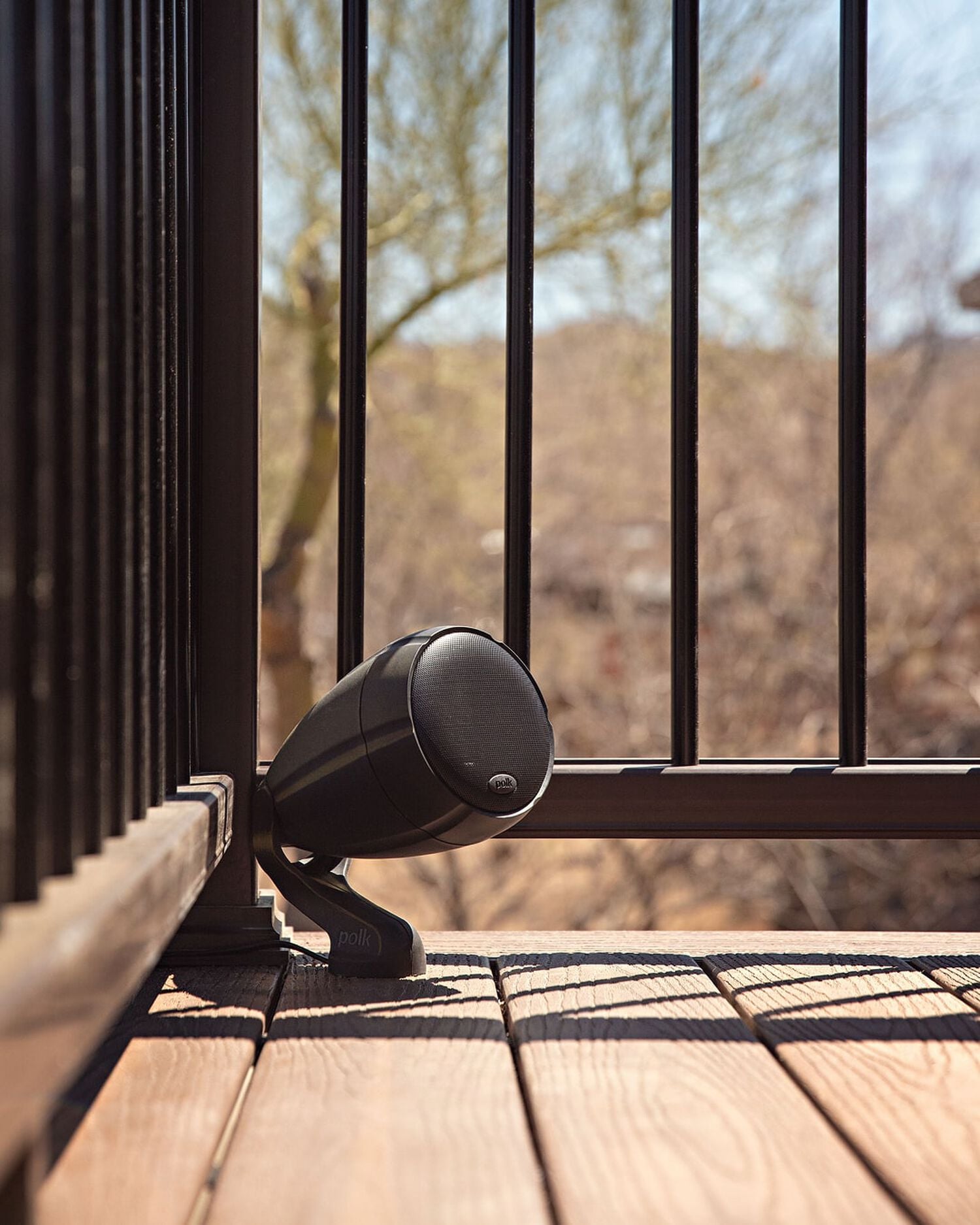 A small outdoor speaker mounted to a deck