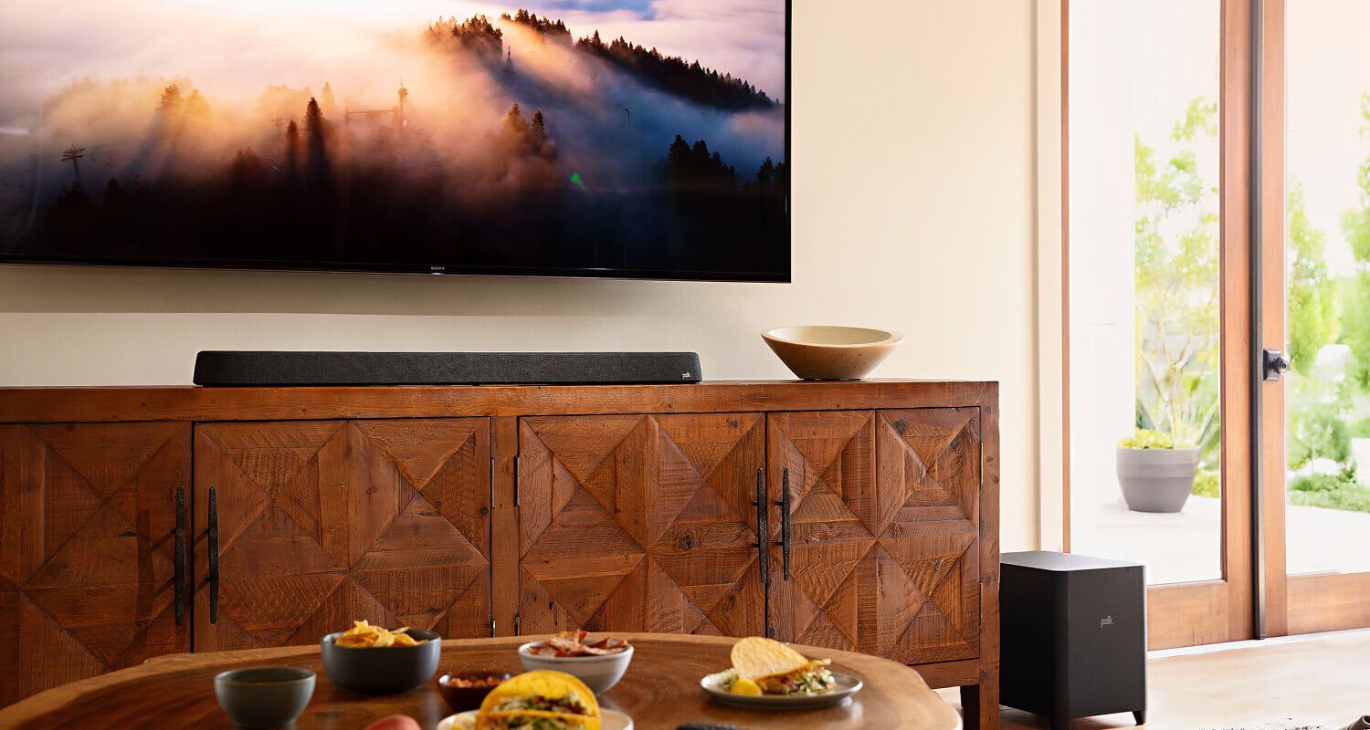 A furnished room with a mounted TV and soundbar.