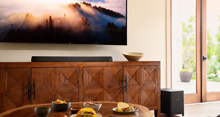 A furnished room with a mounted TV and soundbar.