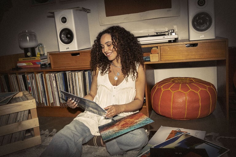 Girl sitting on a floor looking at albums Girl sitting on a floor looking at albums
