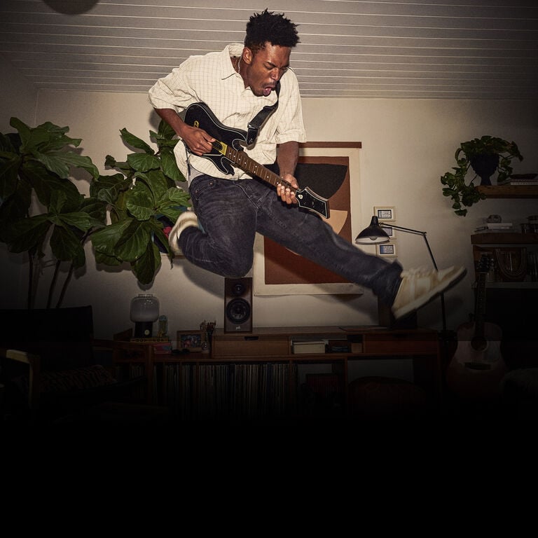 A man jumping with a guitar