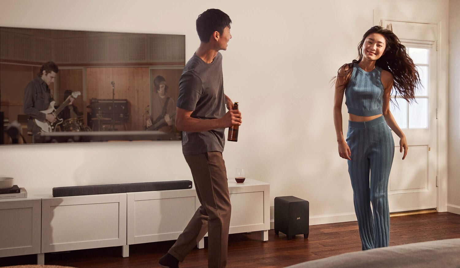 A couple dancing with music from a sound bar.